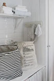 Eco-friendly laundry bag with care instructions, styled in a bright, minimalist laundry space