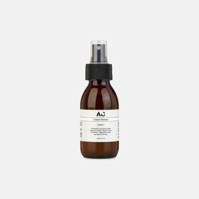 Amber glass spray bottle with black cap and minimalist white label, eco-friendly garment care product