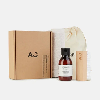 Eco-friendly garment care kit with cleaning solution, brush, cloth, and branded box for luxury clothing maintenance