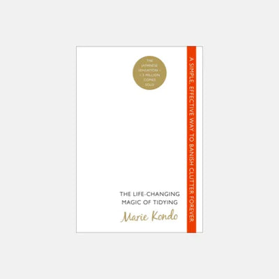 Marie Kondo's 'The Life-Changing Magic of Tidying' book cover with gold seal and orange spine